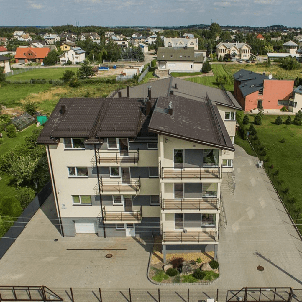 Senelių globos namų pastatas gyvenamajame rajone su balkonais ir sutvarkyta teritorija